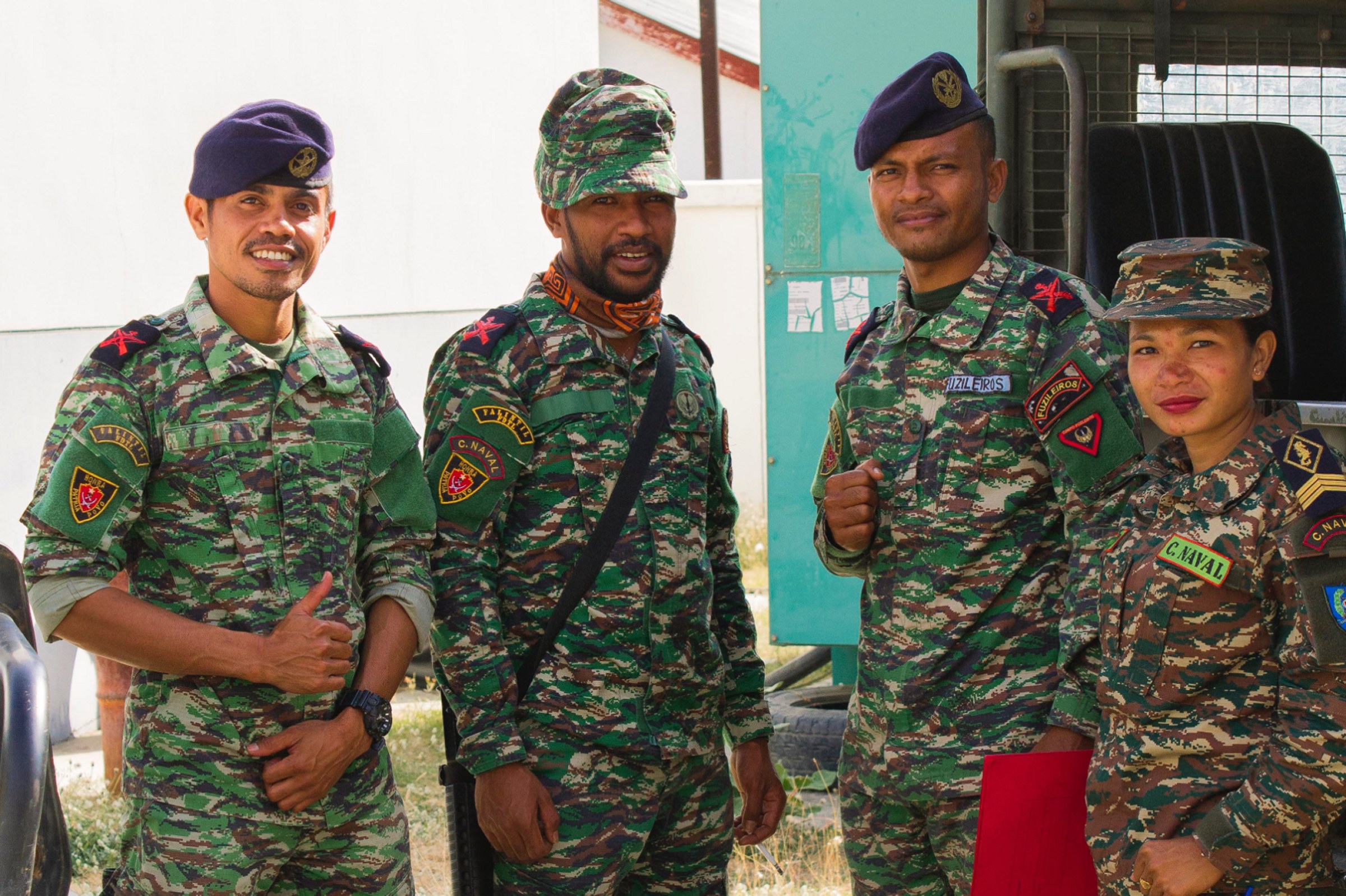 Four F-FDTL personnel in uniform outside a vehicle workshop in Timor-Leste, the people whose sign, stamp and file logistics procedures the platform replaced